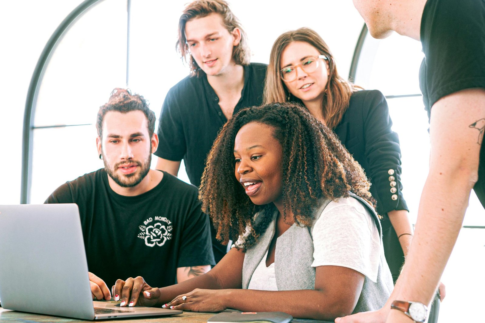 A diverse group of millennials confidently using laptops and smartphones to manage their finances, symbolizing the empowerment AI-powered financial planning tools provide